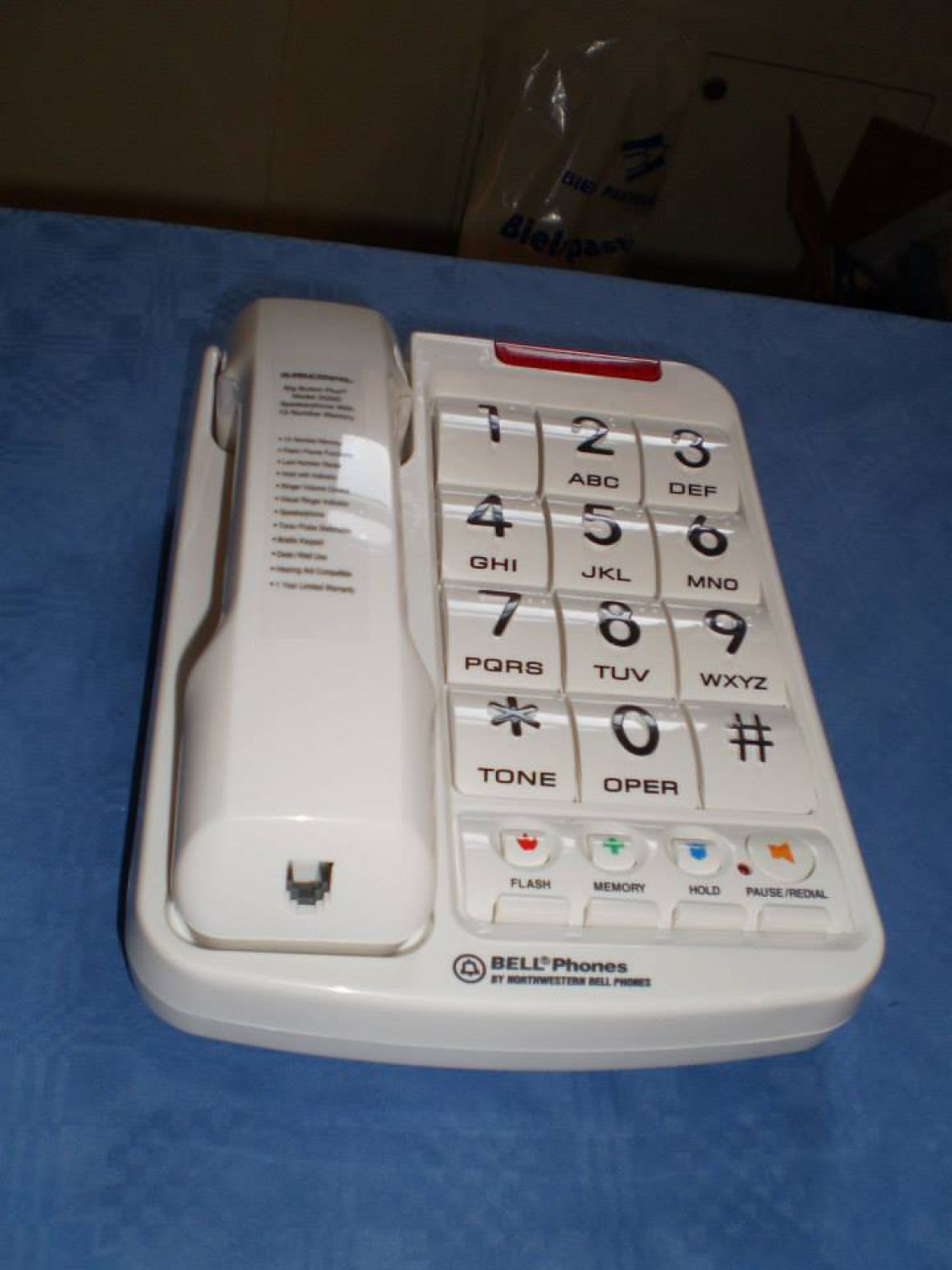 Telefón s klávesnicou označenou reliéfnymi číslicami a Braillovým písmom