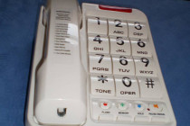 Telefón s klávesnicou označenou reliéfnymi číslicami a Braillovým písmom